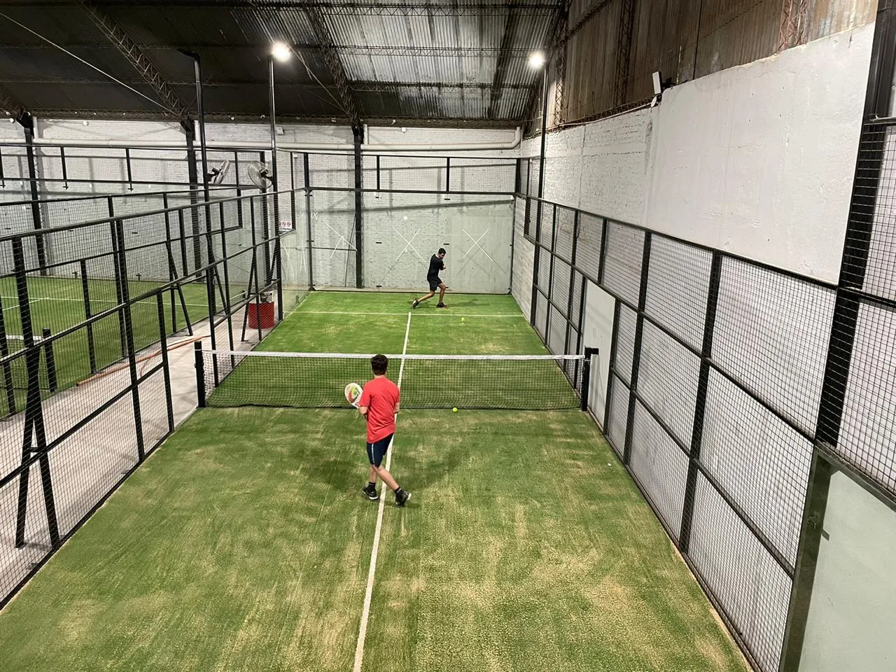 Dos jugadores en un partido en una de las canchas de césped del galpón